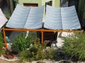 Hellgraues, ausziehbares wasserdichtes Sonnensegel 3x5 m über einer Terrasse mit Holzkonstruktion und Gartenmöbeln