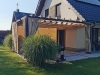 Tan waterproof 3x4 m premium roman blind pergola cover on a modern house patio with a grill and garden grass