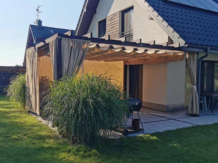 Tan waterproof 3x4 m premium roman blind pergola cover on a modern house patio with a grill and garden grass