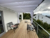 White 3x4 m premium waterproof Roman terrace blind providing shade over a modern wooden deck with outdoor seating