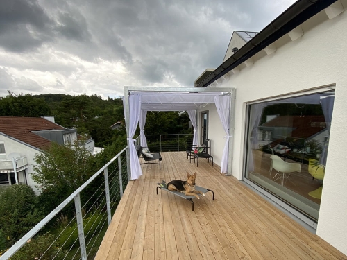 White waterproof premium roman blind for terrace, 3x4 m, installed on a metal frame over a wooden deck with a dog