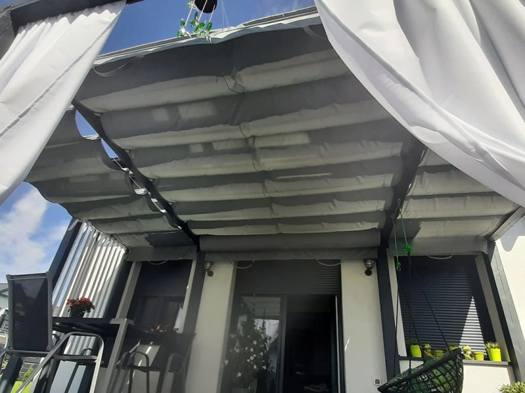 Premium grey outdoor roman blind installed on a white pergola terrace provides waterproof sun protection.