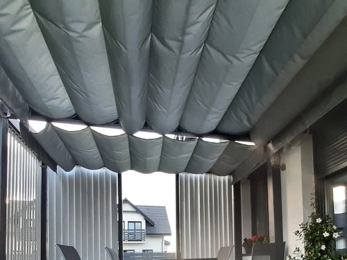 Grey waterproof Roman shade for a 3x4 meter patio providing sun protection over an outdoor seating area