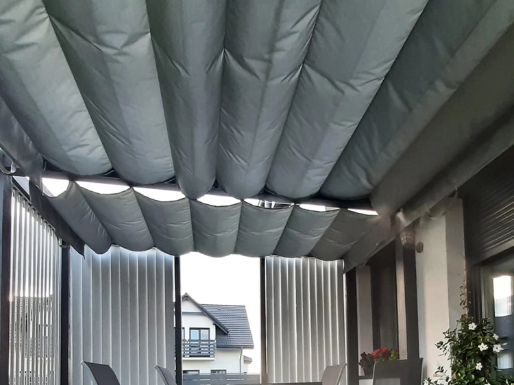 Grey waterproof Roman shade for a 3x4 meter patio providing sun protection over an outdoor seating area