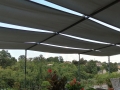 Toldo para pérgola gris impermeable de 0,5x5 m montado sobre estructura metálica en una terraza con vistas al bosque