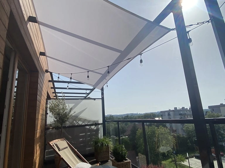 White square 4x4m waterproof sun shade sail installed over a balcony with string lights and outdoor furniture
