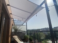 Weißes rechteckiges Sonnensegel 4,2x4,7 m über einer Terrasse mit Loungemöbeln und einer Lichterkette montiert