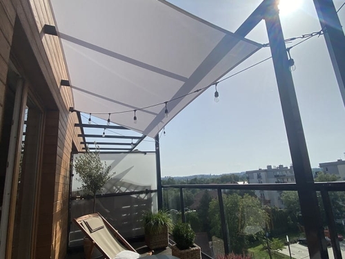 Weißes wasserdichtes Sonnensegel 3x4 m über einer Terrasse mit Loungemöbeln und stimmungsvoller Beleuchtung