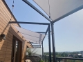 Wasserdichtes rechteckiges Premium-Sonnensegel montiert auf der Terrasse über schwarzem Gestell und Beleuchtung