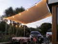 Sandfarbenes Sonnensegel wasserdicht 3x4 m über der Terrasse, abends mit stimmungsvollen Lichterketten dekoriert