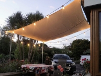 3x4m rectangular waterproof garden shade sail with string lights over an outdoor patio table and chairs.