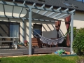 Wasserdichtes Sonnensegel 3x4 m montiert unter einer Pergola auf der Terrasse mit Hängematte und Gartenmöbeln