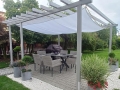 Wasserdichtes Sonnensegel 3x5 m montiert unter einer Pergola über Terrassenmöbeln im Garten