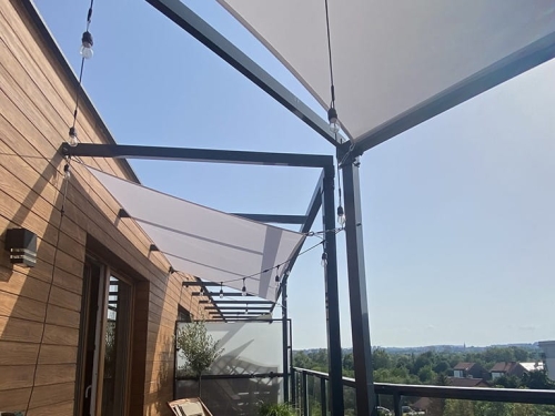 Premium waterproof square 4x4m garden sail providing shade over a modern apartment balcony deck with string lights