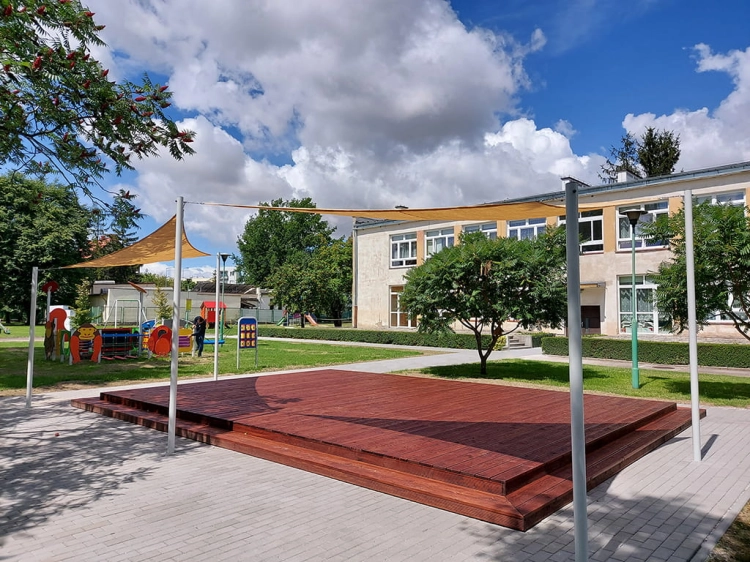Triangular HDPE sun shade sail over a wooden garden stage, 4.2x4.2x5.9 m outdoor canopy providing UV protection