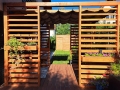 Store romain pare-soleil marron en HDPE monté sur une pergola de terrasse en bois près du jardin