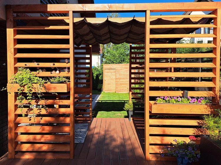 Tenda a pacchetto parasole marrone in HDPE montata su una pergola da terrazzo in legno in giardino