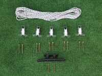 Roman blind pulley system kit with white rope, five pulleys, mounting screws, and a black cleat on a green surface