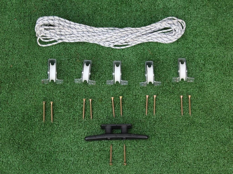 Set für Raffrollos mit weißer Schnur, fünf Rollen, schwarzer Klampe und Schrauben auf grünem Hintergrund