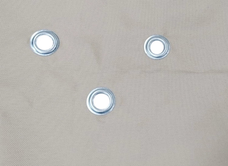 Silver metal drainage grommets on waterproof beige garden sun sail fabric