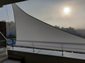 White waterproof triangular sun shade sail installed on a city balcony for UV protection and privacy
