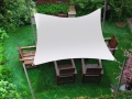 Wasserdichtes quadratisches Sonnensegel 2x2 m in Cremefarbe über einem Holz-Gartenmöbel-Set