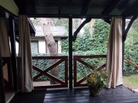 Tenda da giardino impermeabile su misura installata su una terrazza in legno presso un gazebo in beige
