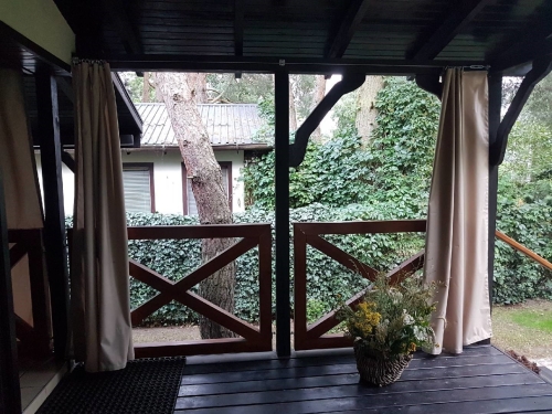 Maßgefertigter wasserdichter Gartenvorhang in Beige, montiert auf einer Holzterrasse am Pavillon