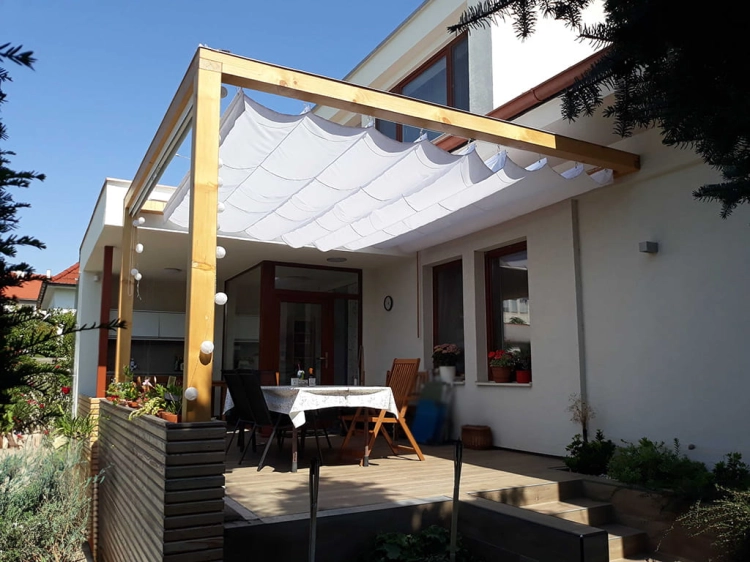 White retractable roman shade installed on a wooden terrace pergola for sun protection and waterproof outdoor comfort.