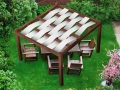 Toldo vela Premium blanco impermeable en pérgola de madera con muebles de exterior