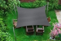 Grijs rechthoekig schaduwdoek 3x4 m van HDPE boven houten tuinmeubelen op een groen gazon