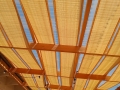 Goldene Sonnenschutz-Segel aus HDPE-Gewebe montiert auf einer Holzkonstruktion einer Terrassenüberdachung