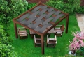 Grauer Sonnenschutzstreifen aus HDPE 0,4x5 m, eingeflochten in eine Holzpergola im Garten mit Loungemöbeln