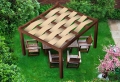 Barna kerti pergola HDPE szövetből készült, összefonódott krémszínű napvédő sávokkal a teraszbútorok felett
