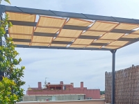 Sandfarbenes Sonnensegel aus HDPE-Gewebe montiert auf einer Metall-Terrassenpergola