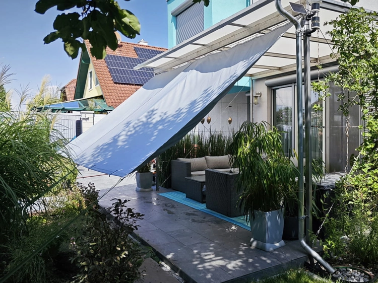 Custom-made waterproof garden curtain providing shade on a modern outdoor terrace with patio furniture.