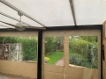 Transparente Planen für die Terrasse mit beigem Rand und Fenster, montiert unter einer Überdachung mit Ventilator