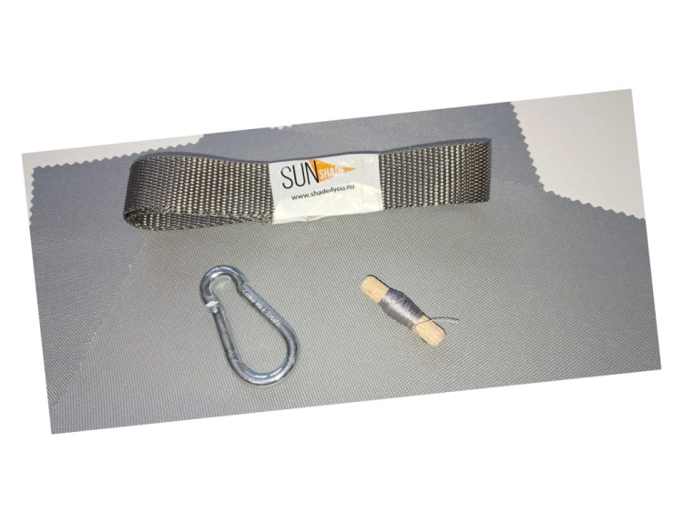 Sun Shade repair kit with grey webbing strap, metal carabiner, and spool of thread on a grey fabric background