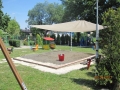 Sonnensegel nach Maß beschattet einen Sandkasten auf dem Spielplatz an einem sonnigen Tag