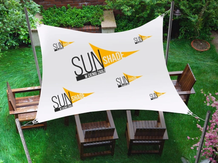 Biela vodeodolná slnečná clona na mieru s potlačou Sun Shade nad dreveným záhradným nábytkom