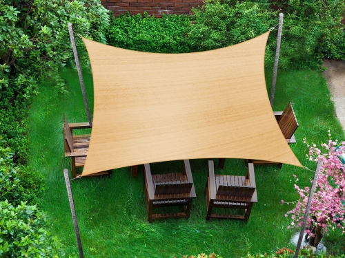 Rechthoekig schaduwdoek 4x6 m van HDPE boven houten tuinmeubelen in een groene tuin