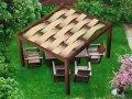 Braunes Sonnenschutz-Sonnensegel aus HDPE-Gewebe, eingeflochten im Dach einer Holzpergola im Garten
