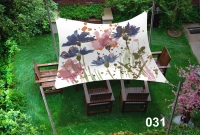 Waterproof garden shade sail with a floral print over a 3x3 m outdoor seating area with wooden chairs