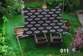 Toldo vela impermeable 3x4 m con motivos negros, montado sobre muebles de madera en el césped