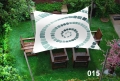 Vela de sombra impermeable 3x4 m con estampado de espiral, protegiendo muebles de madera en un patio premium