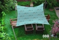 Toldo vela impermeable 3x4 m con diseño de ballenas cubriendo muebles de madera en el césped del jardín