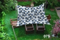 Toldo vela estampado azul y gris de 3x4,5 m extendido sobre sillas de madera en un jardín soleado
