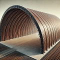 Large industrial arched hangar with custom-made brown tarpaulin covers on a concrete foundation