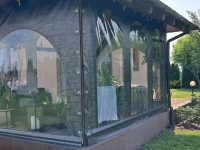 Transparent custom-sized patio tarpaulin with stone pattern print and clear arched windows for weatherproof protection