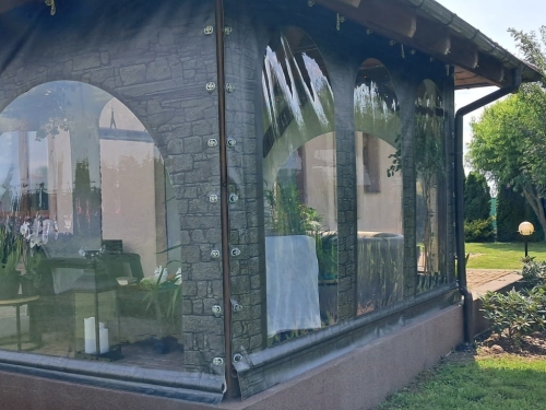 Transparente Terrassenplane mit Steinimitat-Aufdruck, ausgestattet mit Fenstern und Befestigungshalterungen
